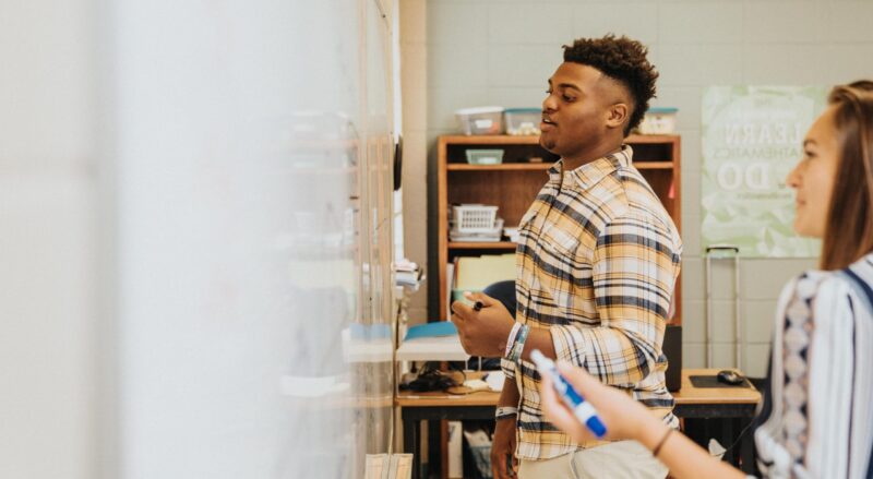 A student writes on a whiteboard